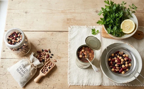 Canned beans and dried beans side by side on a wooden table