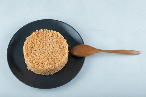 A bowl of organic sweet brown rice topped with vegetables and sesame seeds.